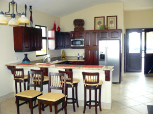 The kitchen is a bright part of the open plan with fine appliances and a breakfast bar.